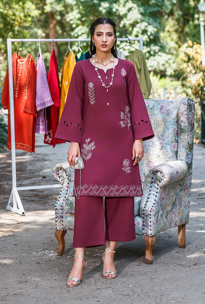 Woman in a burgundy embroidered outfit standing outdoors & wearing RTW Outfit by sehrish kanwal top brand in pakistan.